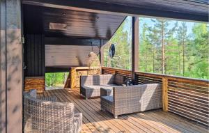a porch with wicker chairs and a table on a deck at Stunning Home In Evje With Kitchen in Evje