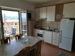 a kitchen with a table and a kitchen with a balcony at Matko 1 in Bol