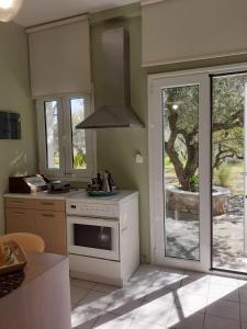 a kitchen with a stove top oven next to a window at Olive House in Kalamaki