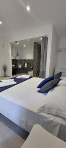 uma grande cama branca com almofadas azuis num quarto em Miramare rooms b&b em Avola