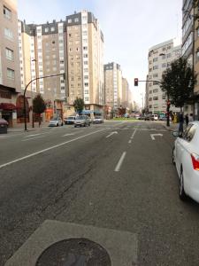 eine leere Stadtstraße mit Autos und Gebäuden in der Unterkunft La Cabaña in Vigo