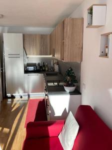 - une petite cuisine avec un canapé rouge dans une chambre dans l'établissement Appartamento nuovo tra Bormio e Livigno, à Valdidentro