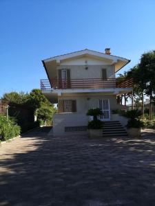 ein weißes Haus mit einer Veranda und einer Auffahrt in der Unterkunft Villa Lagioia 1 in Bari