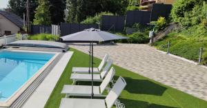 a pool with lounge chairs and an umbrella at AQUA SOLAR APARTMANHÁZ in Miskolc