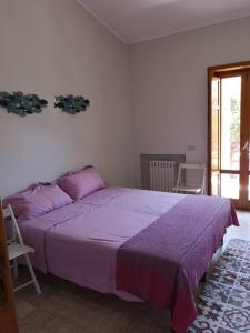 ein Schlafzimmer mit einem lila Bett in einem Zimmer in der Unterkunft Villa Lagioia 1 in Bari