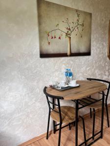 a table with two chairs and a painting on a wall at Homies Inn in Celiny