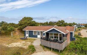 a small house with a deck on a beach at Kis in Fanø