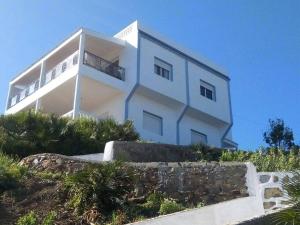 a white building on top of a hill at Villa Plage Ksar Sghir in Melîyech