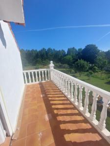 een balkon met een witte leuning en uitzicht bij BertoaLand Relax y Diversión Apartamento de 2 dormitorios dobles con terraza privada y zona de juegos compartida in Carballo