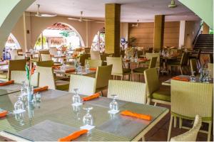 uma sala de jantar com mesas e cadeiras com guardanapos laranja em Private Owned Suite at Coronado Luxury Suite Hotel & Golf Course em Playa Coronado