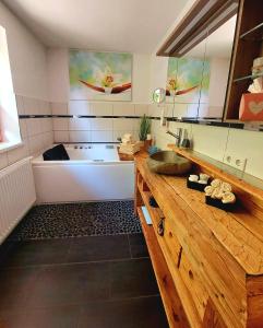 La salle de bains est pourvue d'une baignoire et d'un comptoir en bois. dans l'établissement Ferienhaus Goldener Anker Unterach am Attersee, à Unterach am Attersee