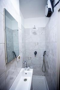 a white bathroom with a sink and a shower at Haran in Jerusalem
