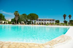a large swimming pool with blue water at Villa Conca Marco in Torre dell'Orso