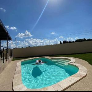 阿维尼翁Magnifique villa pour le festival d'Avignon的在后院游泳池游泳的人