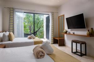 1 Schlafzimmer mit 2 Betten und einem großen Fenster in der Unterkunft Spectacular 4BR Villa for 14ppl Pool and Concierge in Tulum