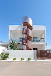 a building with a spiral staircase in front of it at Dolcirive B&B - Porto Cesareo in Porto Cesareo