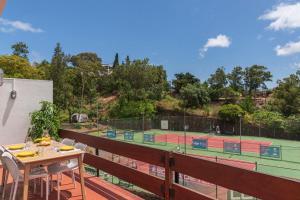 a balcony with a table and two tennis courts at Matur I by An Island Apart in Água de Pena