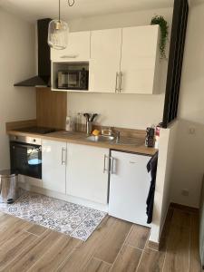 a kitchen with white cabinets and a sink at Mistral gagnant - parking privé in Cassis