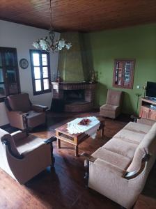 a living room with couches and a table and a fireplace at House Christina in Palaioi Poroi