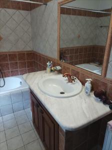 a bathroom with a sink and a mirror and a tub at House Christina in Palaioi Poroi