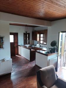 a large kitchen with wooden ceilings and a table at House Christina in Palaioi Poroi