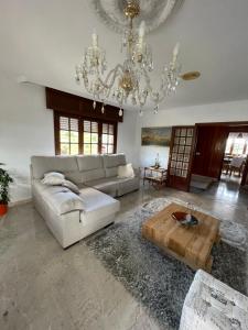 uma sala de estar com um sofá e um lustre em Casa Arxon em Meaño