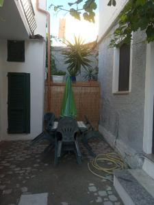 d'une terrasse avec une table et un parasol vert. dans l'établissement Holiday house in Siniscola, à Siniscola