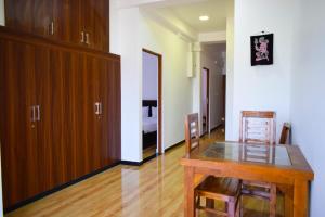 a dining room with a wooden table and a bedroom at Holiday Villa in Trincomalee