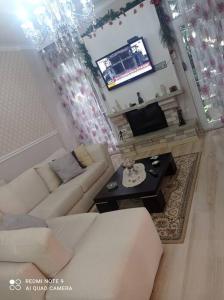 sala de estar con sofá blanco y TV en Lake Harmony Haven, en Tushemisht