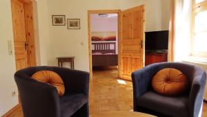 a living room with two chairs and a bedroom at Ferienwohnung "Specker Krug" in Kargow