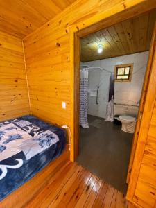 sypialnia z łóżkiem w drewnianym domku w obiekcie Chalé Casa de campo para família! w mieście Urubici