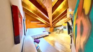 una sala de estar con un sofá blanco y techos de madera. en La buhardilla de Escarrilla - tucasaenlospirineos, en Escarrilla