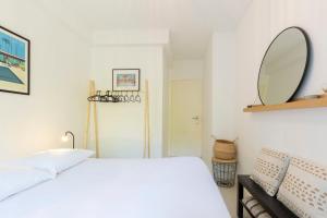 1 dormitorio con cama blanca y espejo en WE CANNES ! Exceptional 4 rooms apartment Cannes Center swimming pool, en Cannes
