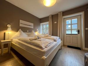 a bedroom with a large bed and a window at Deichhof Whg Luana in Dunsum
