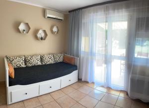 1 dormitorio con 1 cama y puerta corredera de cristal en SunSet Beach Apartman, en Balatonfűzfő
