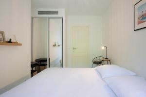 1 dormitorio con 1 cama blanca grande y espejo en WE CANNES ! Exceptional 4 rooms apartment Cannes Center swimming pool, en Cannes