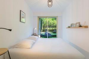 1 cama blanca grande en una habitación con ventana en WE CANNES ! Exceptional 4 rooms apartment Cannes Center swimming pool, en Cannes