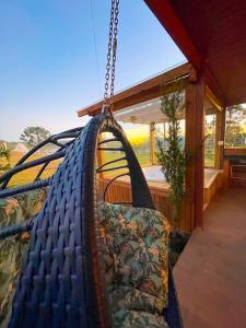 a hammock hanging from a porch in a house at Chalé Casa de campo para família! in Urubici