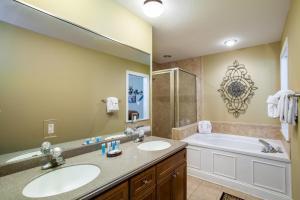 a bathroom with two sinks and a tub and a large mirror at Convenient Gatlinburg Condo in Gatlinburg +37 photos