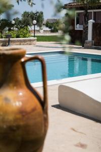 un jarrón marrón sentado junto a una piscina en Villa Bianca - Private swimming pool - Center - by ClickSalento, en Ostuni