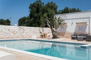 una piscina en una villa con una pared de piedra en Villa Bianca - Private swimming pool - Center - by ClickSalento, en Ostuni