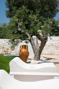 un jarrón grande sentado junto a un árbol en Villa Bianca - Private swimming pool - Center - by ClickSalento, en Ostuni