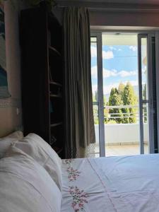 a bedroom with a bed and a view of a balcony at Villa Rahati in Kroústas