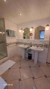 baño con 2 lavabos y espejo grande en B&B Het Oude Doktershuys, 