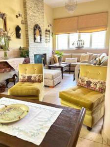 a living room with yellow chairs and a table at Villa Rahati in Kroústas