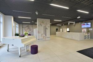 an office with a white piano in a lobby at Apartment 153 - Rezidence Eliska - Prague 9 in Prague