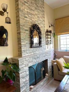 sala de estar con chimenea de piedra y espejo en Villa Rahati en Kroústas