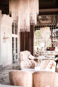 a living room with two chairs and a chandelier at Hotel Aristocrat in Chernivtsi