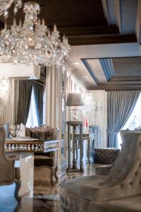 a living room with a chandelier and a table at Hotel Aristocrat in Chernivtsi