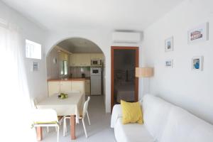 Sala de estar blanca con sofá blanco y mesa en TU CASA CERCA DEL MAR, en Torrox